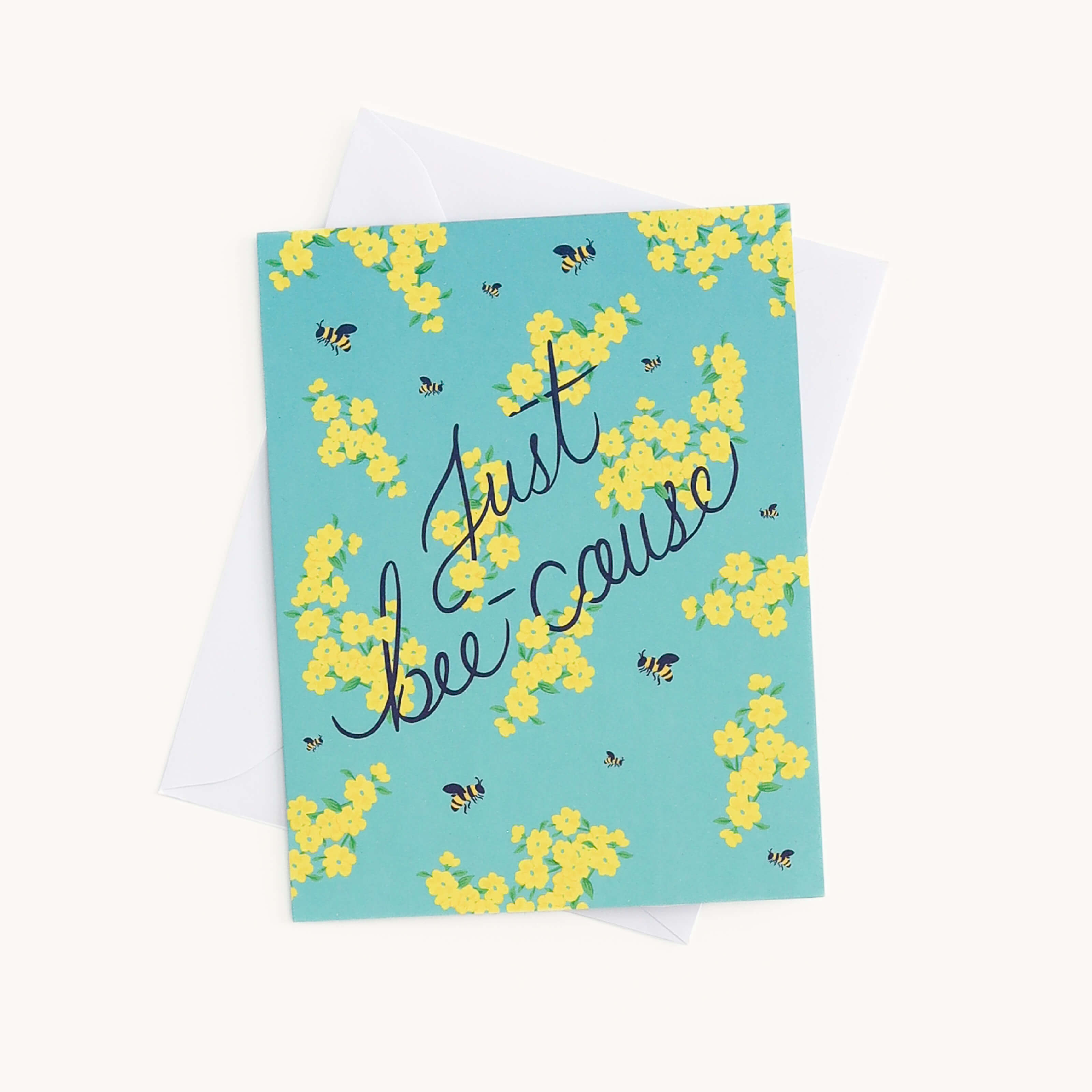 A charming Simplified Boxed Card Set includes a card with a green and yellow floral design and small bees, featuring Just bee-cause elegantly scripted. Perfect for any occasion with a white envelope partially visible behind.