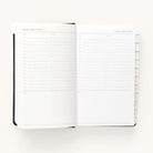 The 2024-2025 Daily Dapperdesk Planner - Black Tie by Simplified showcases a daily schedule for Saturday, August 10, 2024, with an elegant leatherette cover. Each page in this 12-month planner contains hourly slots from 7 AM to 8 PM plus To-Do and Notes sections, with visible tabs marking the months.