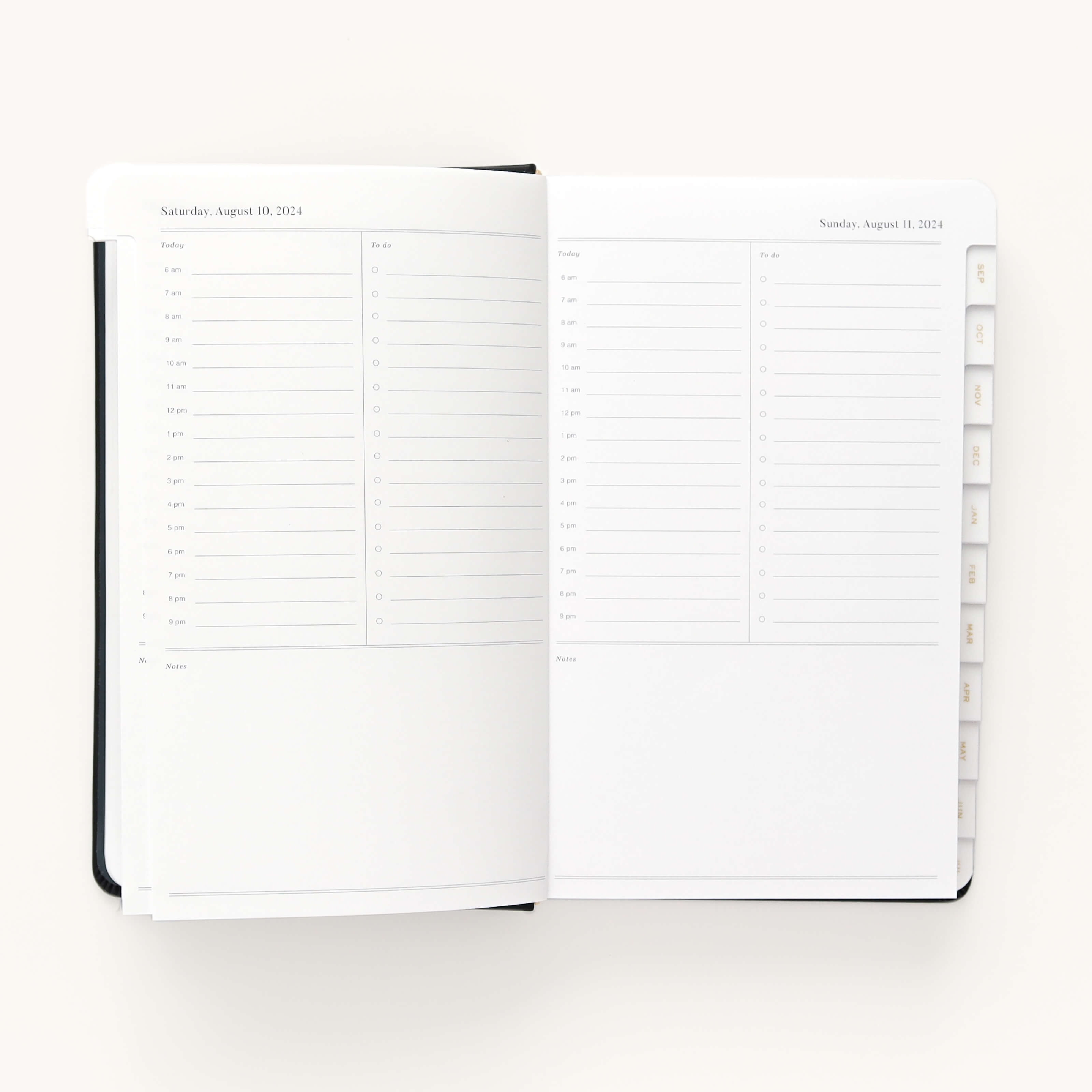 The 2024-2025 Daily Dapperdesk Planner - Black Tie by Simplified showcases a daily schedule for Saturday, August 10, 2024, with an elegant leatherette cover. Each page in this 12-month planner contains hourly slots from 7 AM to 8 PM plus To-Do and Notes sections, with visible tabs marking the months.