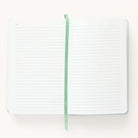 2024-2025 Daily Simplified Planner in the Sea Salt leatherette cover open to the notes pages. Features a two-page spread with blank lined notes pages and sage grosgrain ribbon page marker. 