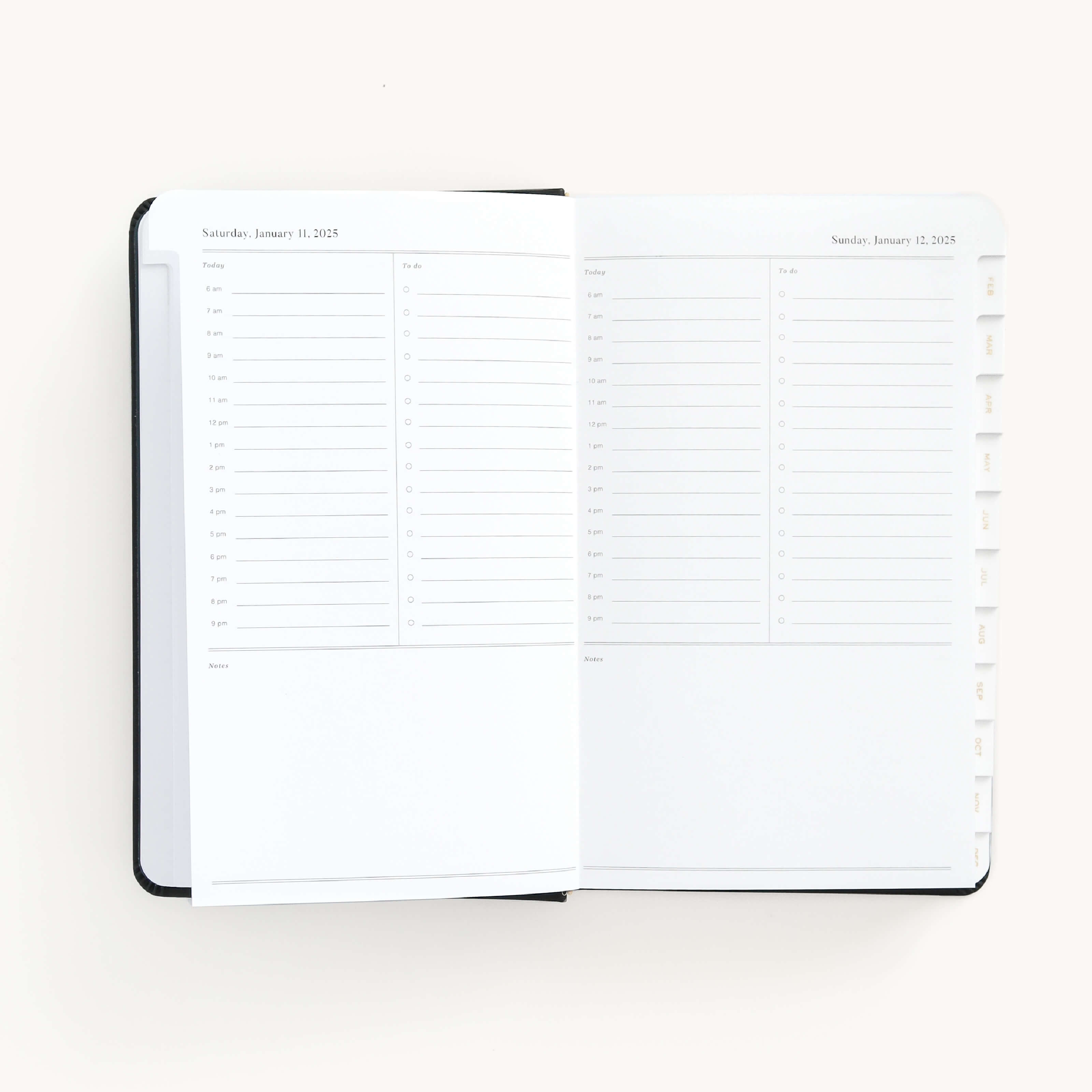 2025 Daily Dapperdesk Planner by Emily Ley in the Black Tie leatherette cover open to a two-page daily spread featuring Saturday and Sunday. Features a clean, minimalistic design with lined sections for daily tasks, to-do lists, and notes.