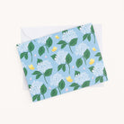 A Simplified Boxed Card Set greeting card features a light blue background with white flowers, green leaves, and yellow butterflies. It comes with a plain white envelope, perfect for any occasion.