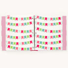 An open scrapbook showcases colorful pages with vibrant bunting banners in red, green, and blue, bound by metal rings. Reminiscent of Simplifieds Big Kid Book - Raspberry, the cover sports a playful pink polka dot pattern.