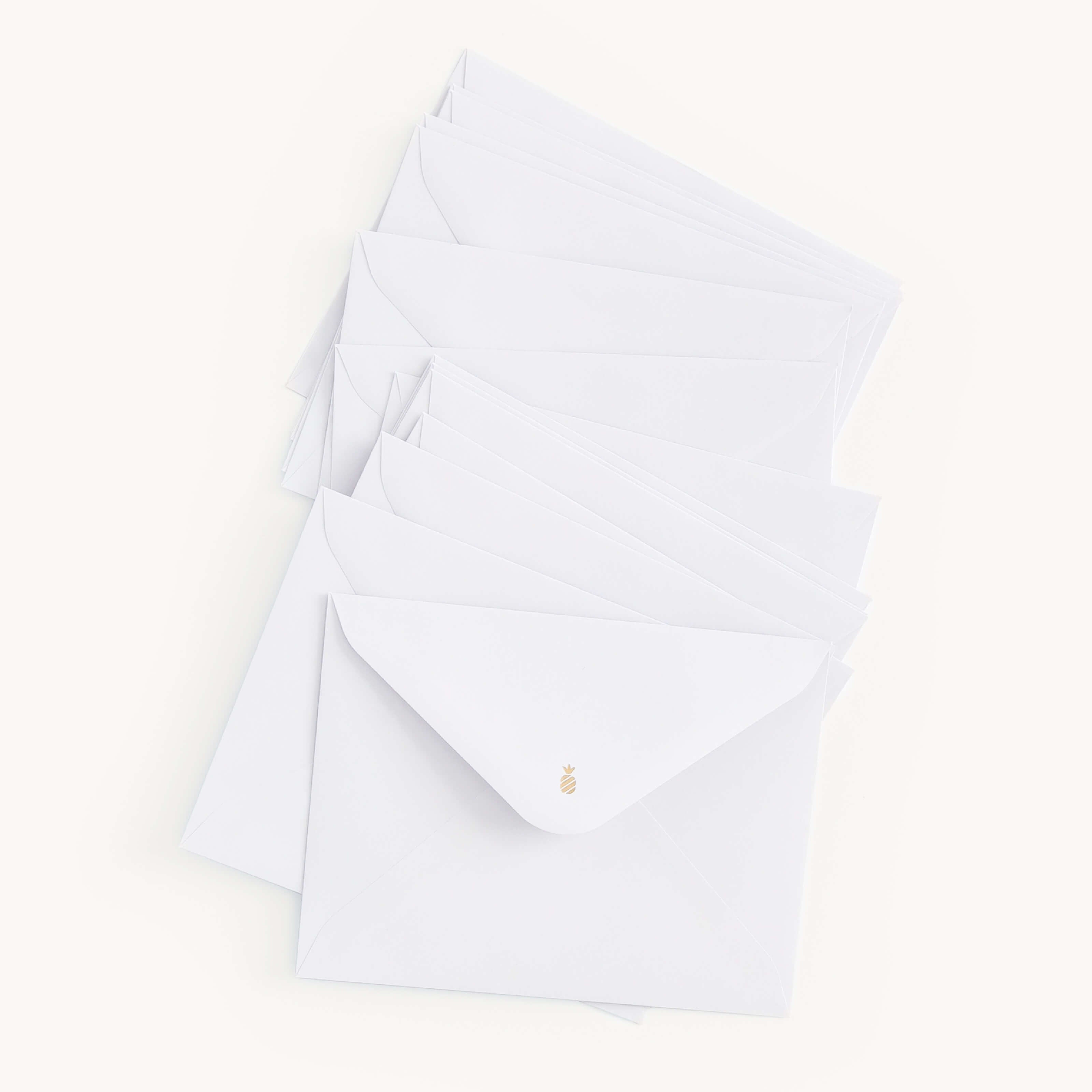 The Simplified Boxed Card Set features a chic stack of white envelopes, each sealed with small gold stickers, against a plain white background. It perfectly suits any occasion with its versatile designs for every need.