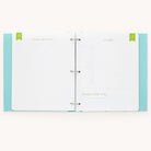 The Baby Book - Mint by Simplified features a light blue cover with white polka dots. Inside, green and grey text on white pages outline sections for goal tracking, notes, and guided writing under Growing and Your Focus headings, creating a charming customizable planner.