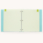 Simplifieds Baby Book - Mint features a turquoise cover with white polka dots, a green and white checkered interior with three metal rings, and includes two green tabs at the top for guided writing space with customizable page packs.