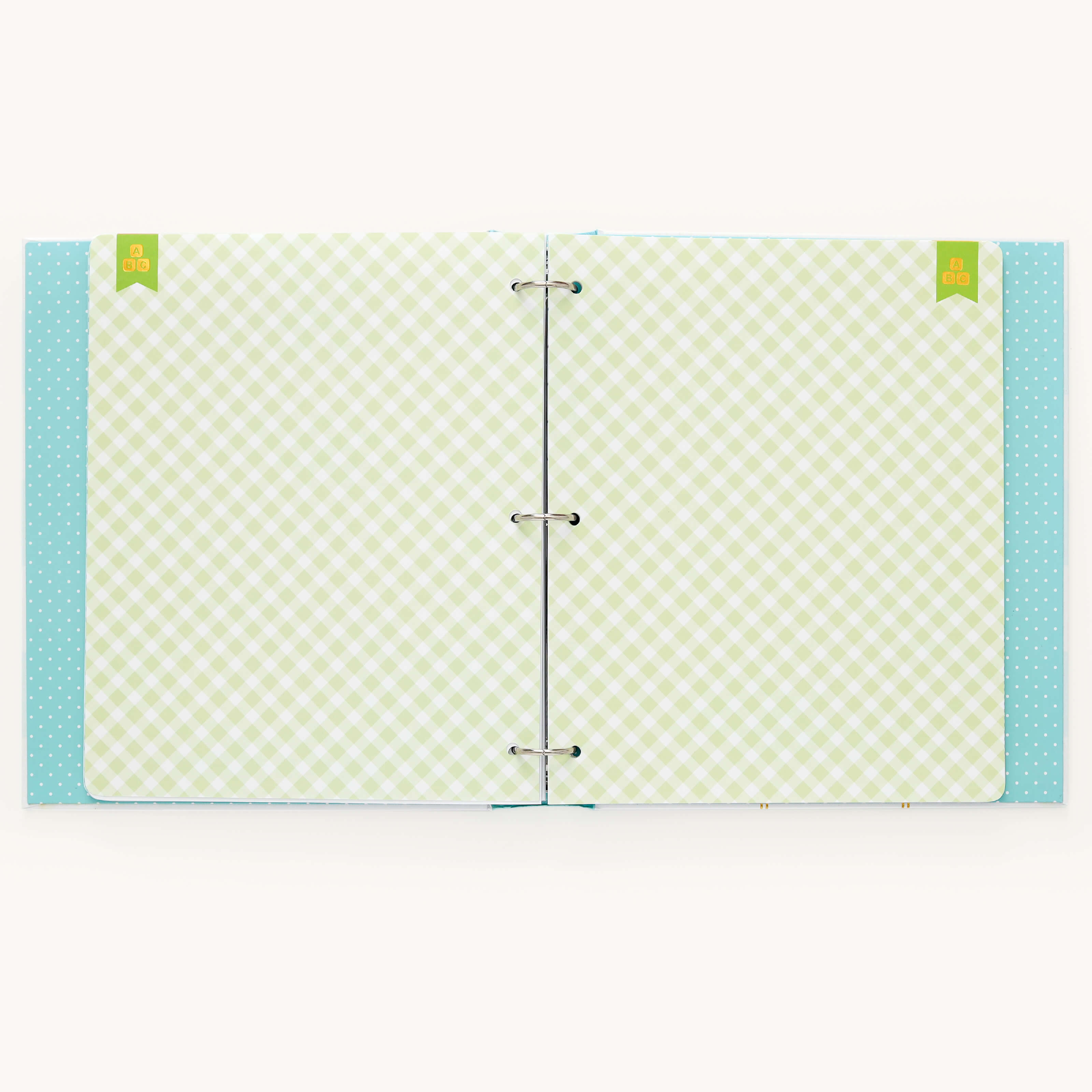 Simplifieds Baby Book - Mint features a turquoise cover with white polka dots, a green and white checkered interior with three metal rings, and includes two green tabs at the top for guided writing space with customizable page packs.