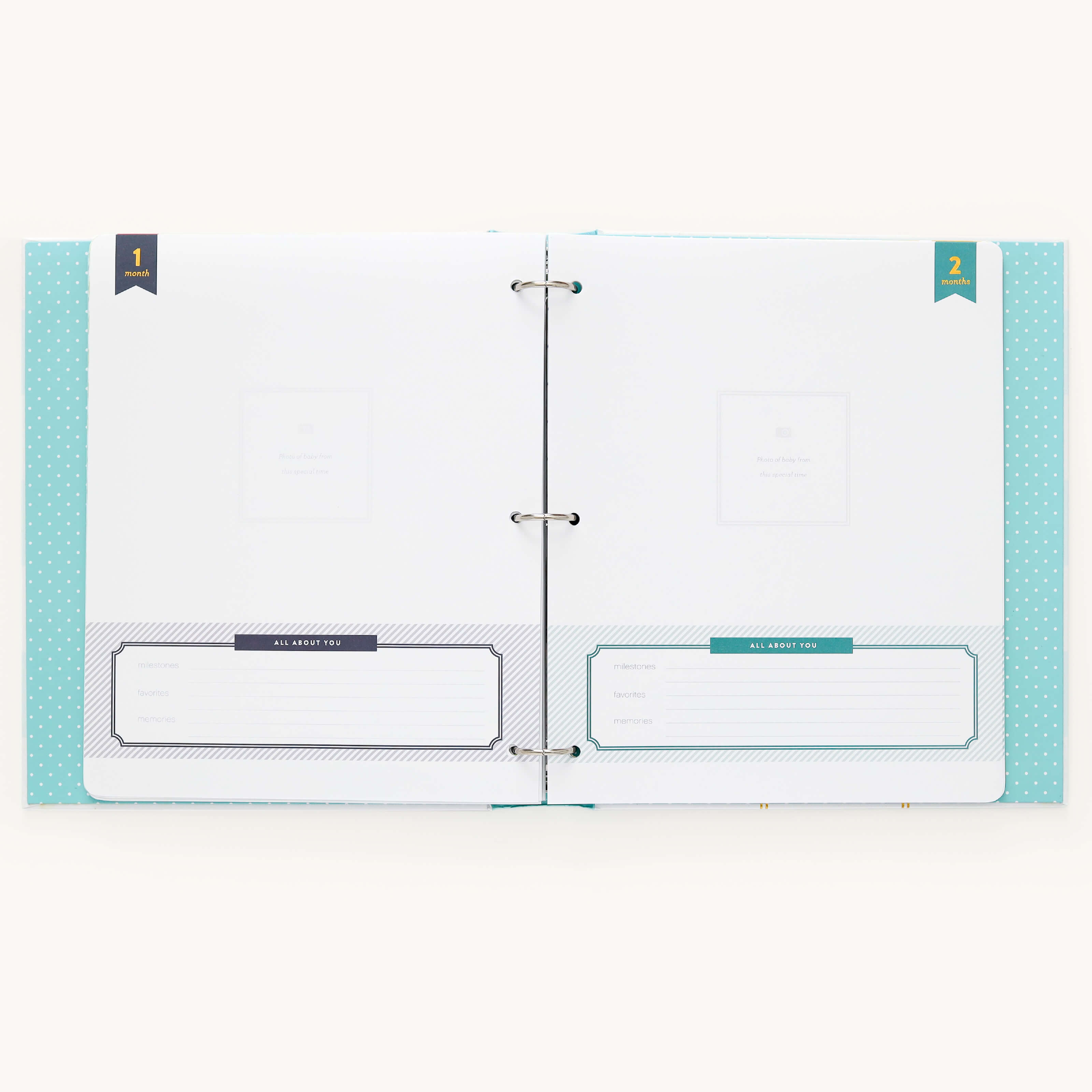 Open the Baby Book - Mint by Simplified, featuring white pages with guided writing sections and All About You labeled areas for personal entries. Two small flags marked 1 and 2 help organize memories in this easy-to-use, customized baby book.