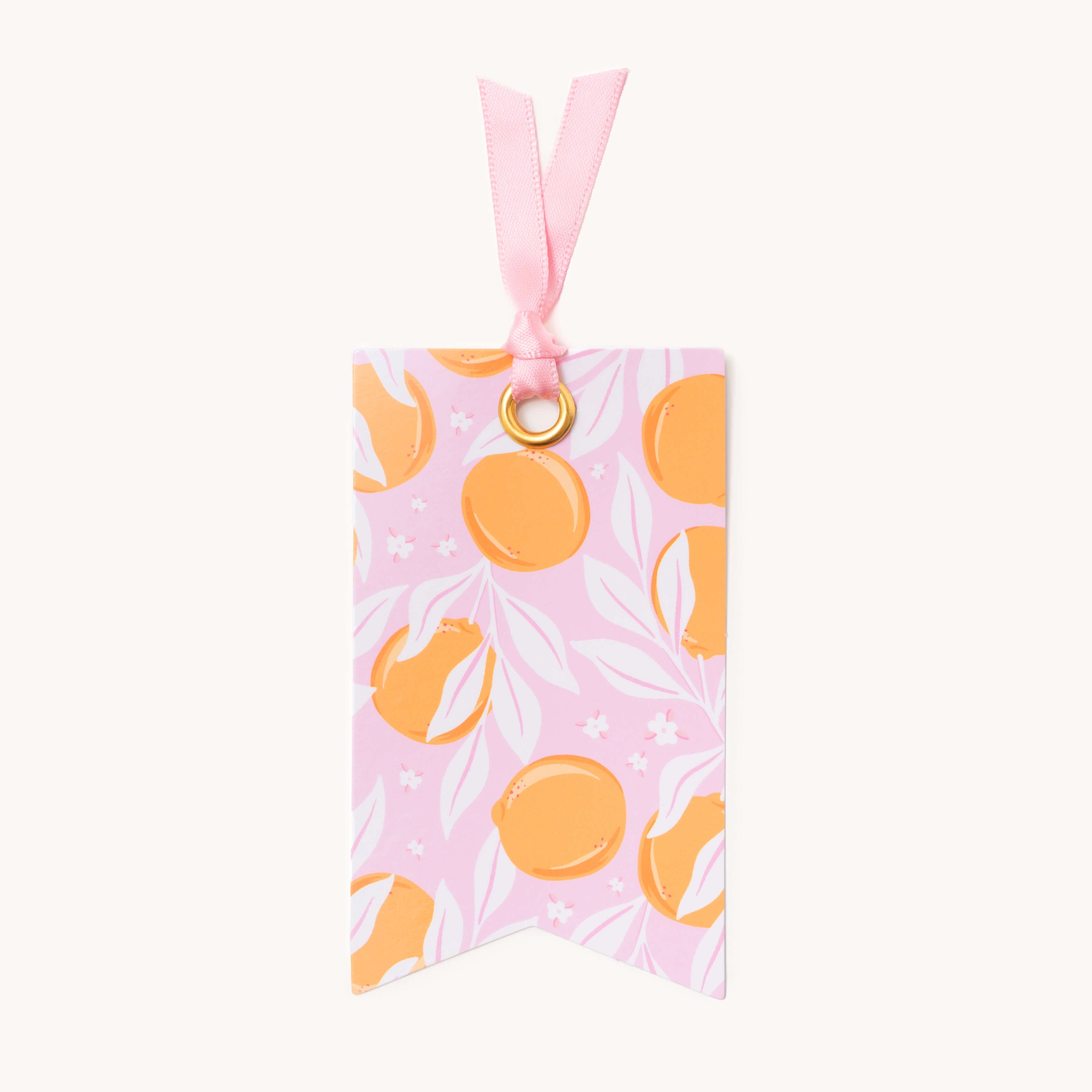 The Simplified Gift Tag Set - Blush Oranges showcases a pink design with an orange and pale green fruit pattern, leaves, and small white flowers. It features a gold grommet and matching ribbon, adding elegance to your gifts.