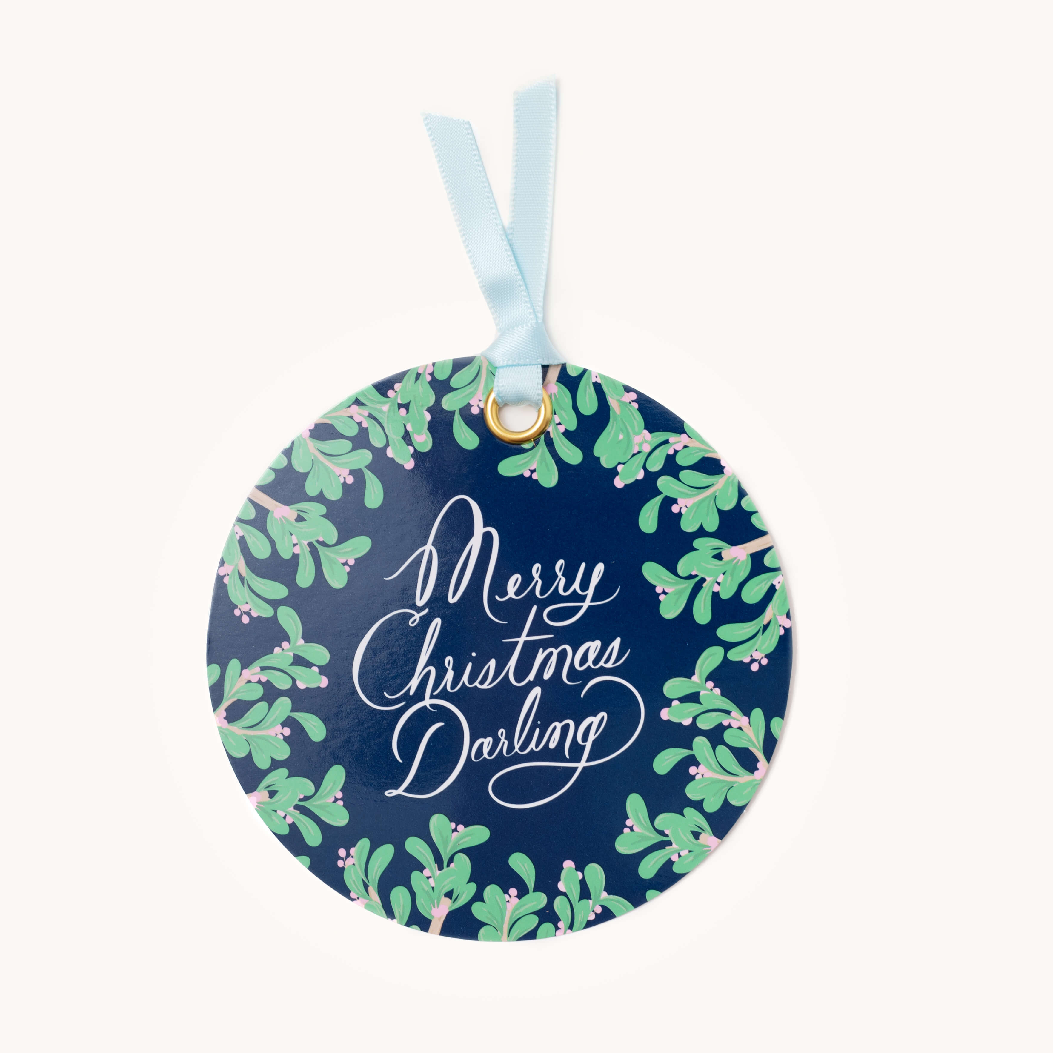 The Gift Tag Set - Merry Christmas Darling by Simplified features a round, dark blue ornament with a light blue ribbon. Adorned with green mistletoe and Merry Christmas Darling in white script, it adds charm and personalization to your gifts.