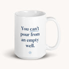 The Simplified Mug - Empty Well is a 15 oz. white ceramic mug that is dishwasher-safe and features the phrase You cant pour from an empty well in bold blue text.