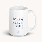 The 15 oz. Mug - Its Okay by Simplified features the uplifting message Its okay not to do it all, in blue text with two tiny exclamation marks at the bottom.