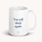 The Simplified 15 oz. Mug - You Will Sleep Again features a white ceramic design with an encouraging blue text message, thick handle, and a minimalist look.