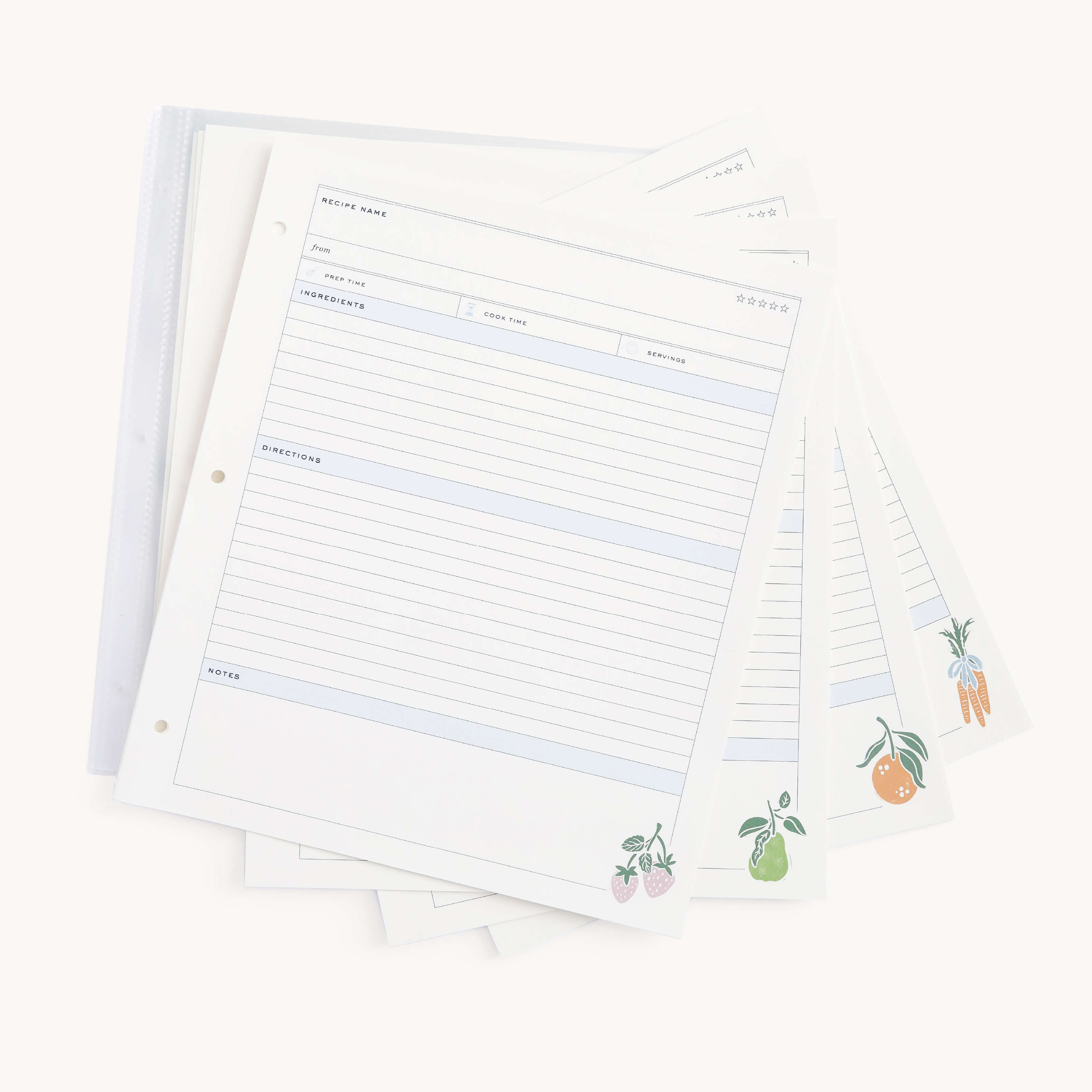 The Simplified Recipe Binder Page Pack includes blank pages fanned out on a white surface, each featuring sections for the recipe name, ingredients, directions, and illustrations of fruits or vegetables like carrots and pears in the corners. Theyre nestled within a partially visible plastic binder for orderly culinary inspiration.